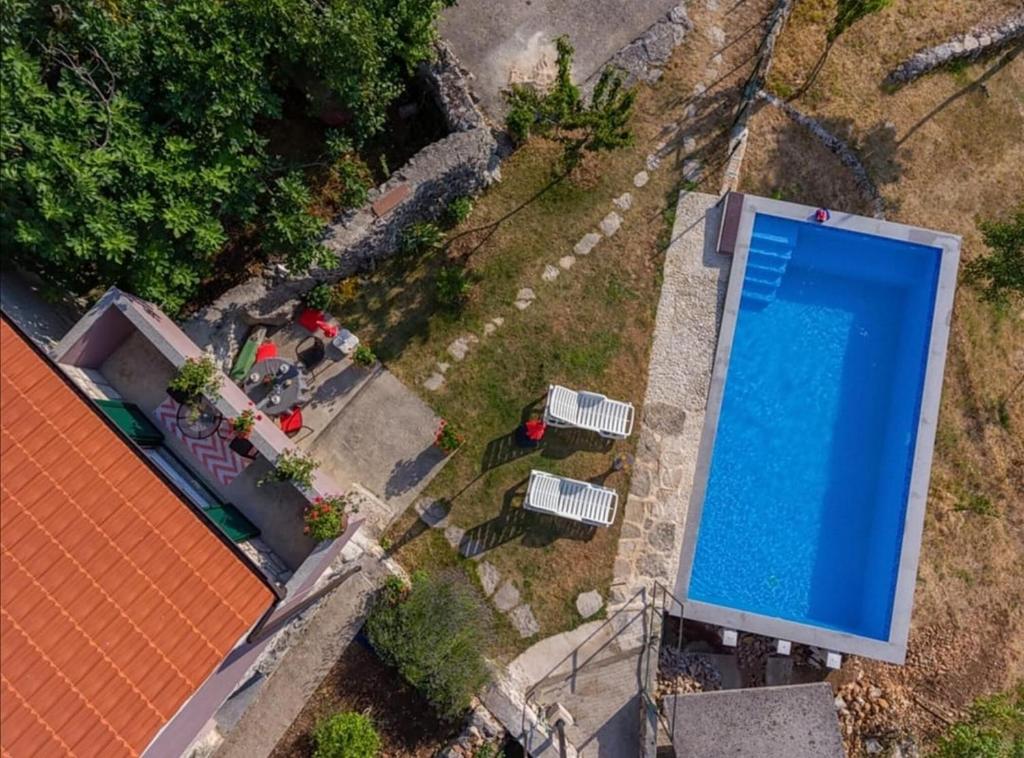 - une vue sur la piscine située à côté d'une maison dans l'établissement House Honey, à Lovreć