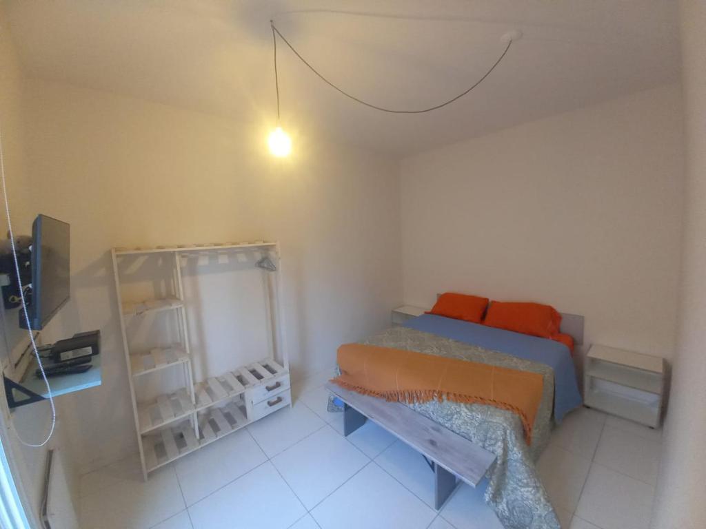 Habitación pequeña con cama y espejo. en La Faustina en Maipú