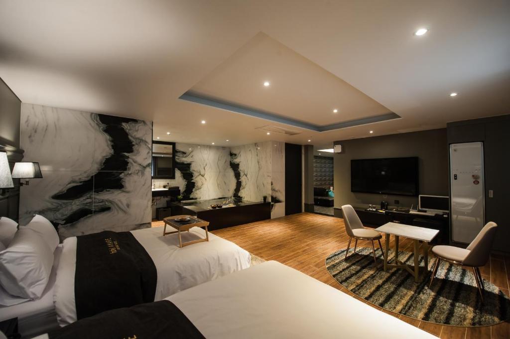 um quarto de hotel com uma cama e uma secretária em Amare em Suwon