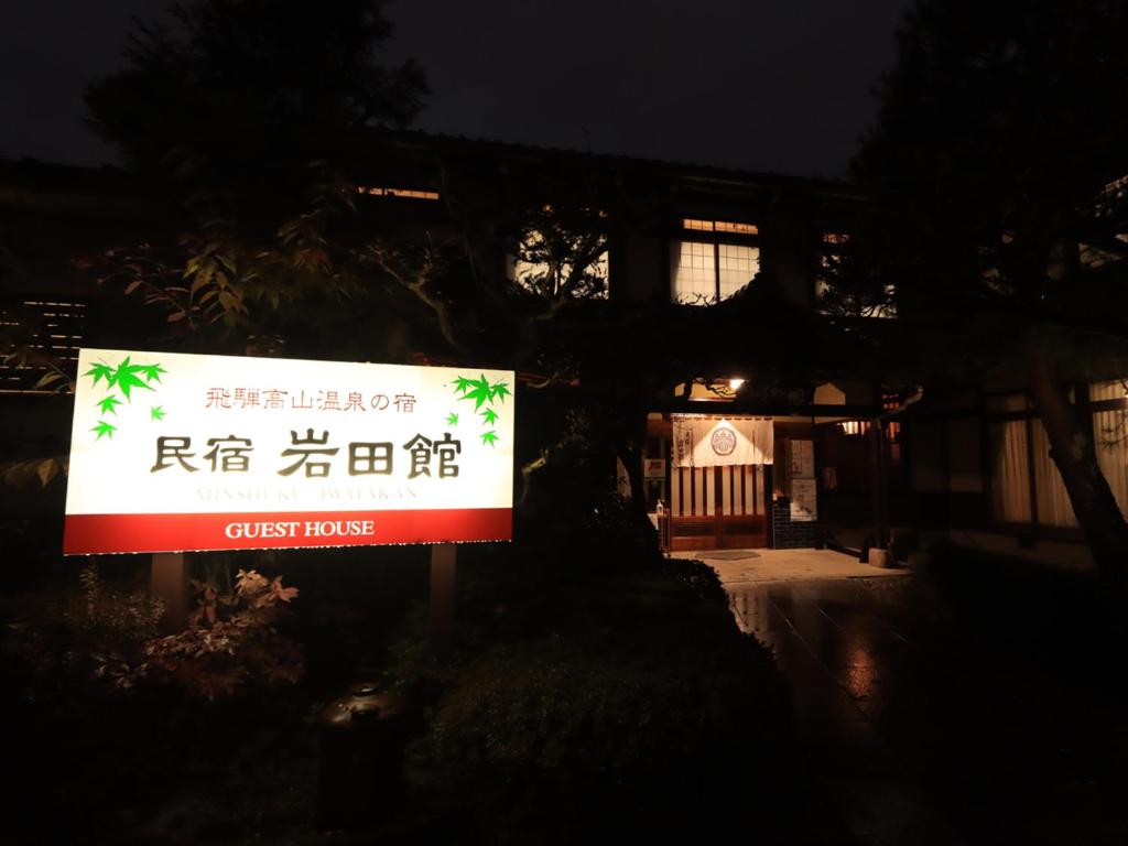 a sign in front of a building at night at Minshuku Iwatakan in Takayama