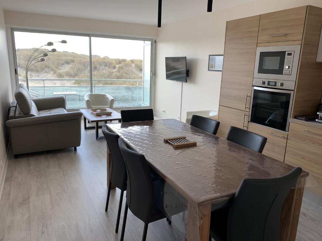 une cuisine et un salon avec une table et des chaises dans l'établissement Appartement rénové avec garage privé, balcon et vue mer - FR-1-482-87, à Fort-Mahon-Plage