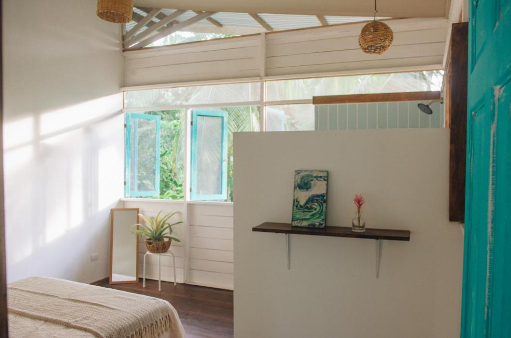 a bedroom with a bed and a window at Casa BOHÖ in Puerto Viejo