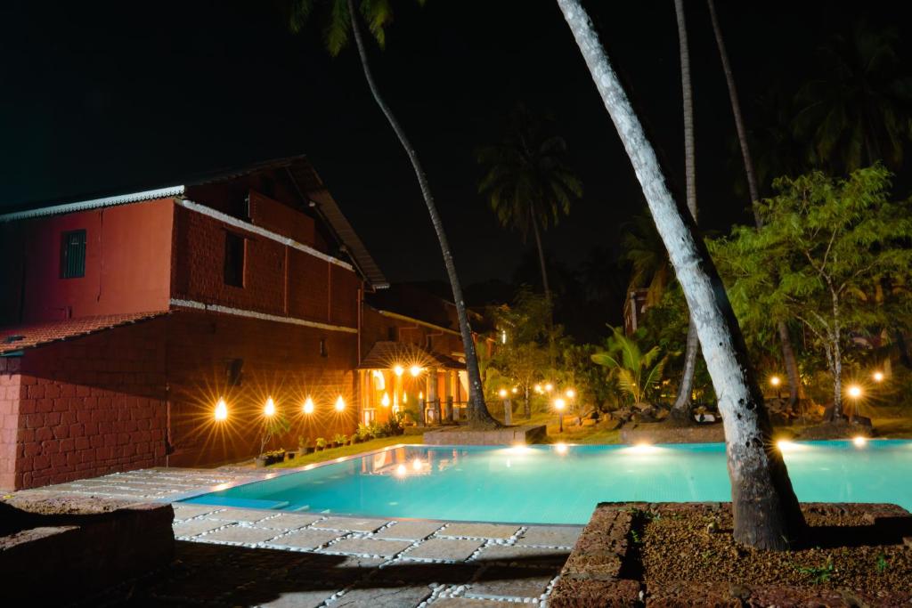 a swimming pool in front of a building at night at Sawantwadi Palace Boutique Art Hotel in Sawantwadi