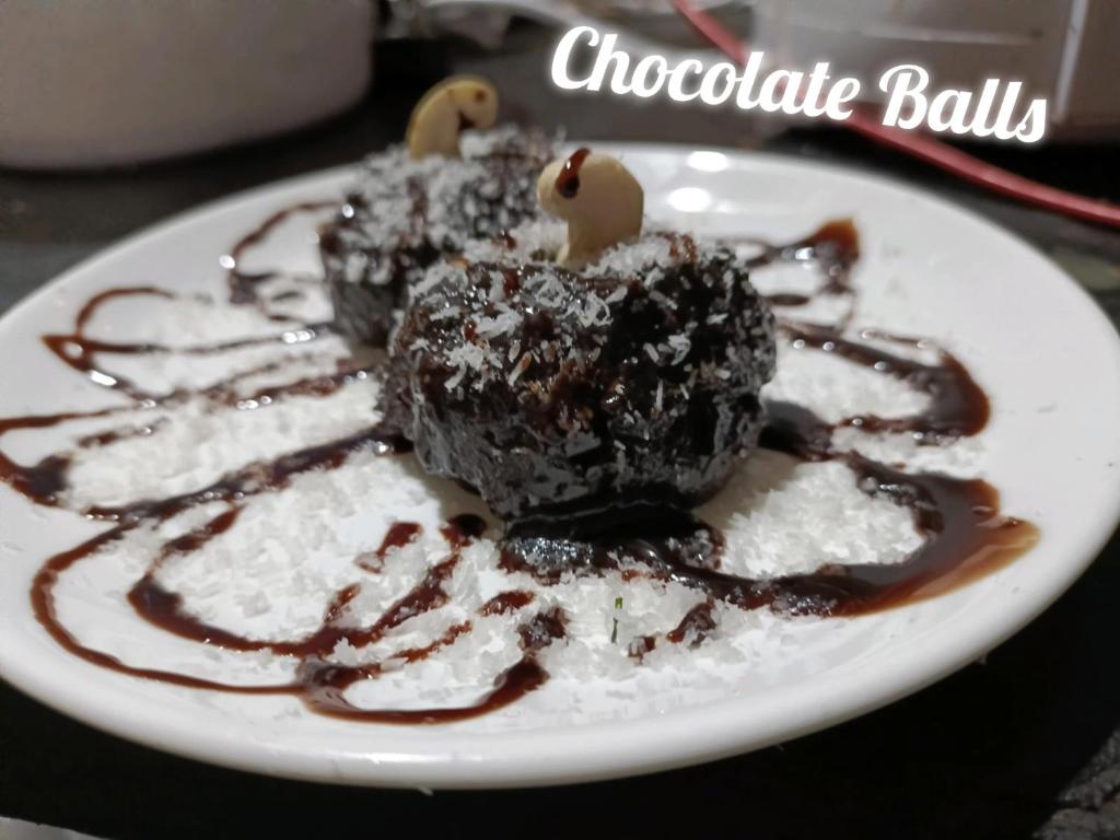 un piatto bianco con palle di cioccolato sopra al riso di Greenstone Resort Hampi a Hampi