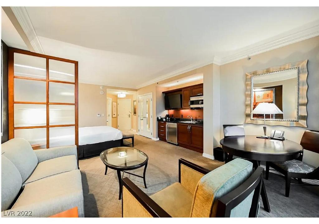 ein Hotelzimmer mit einem Bett und einem Wohnzimmer in der Unterkunft Private Studio - No Resort Fee - The Signature at MGM Grand Tower B in Las Vegas