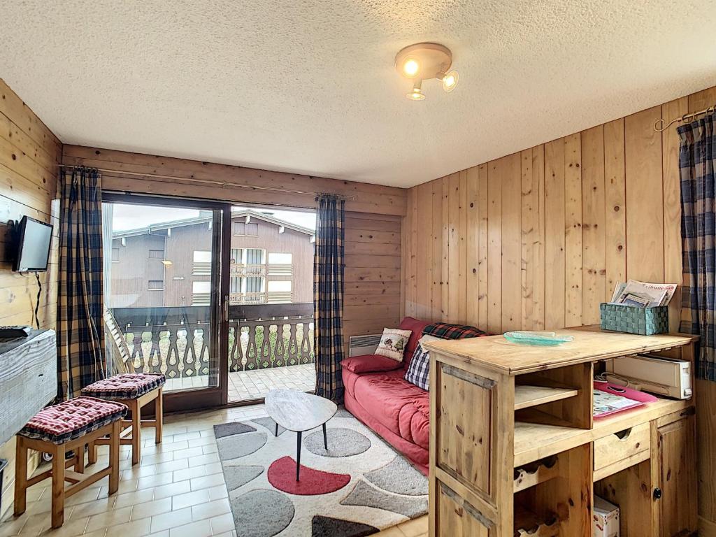 uma sala de estar com um sofá vermelho e uma varanda em Studio Combloux, 1 pièce, 4 personnes - FR-1-560-70 em Combloux