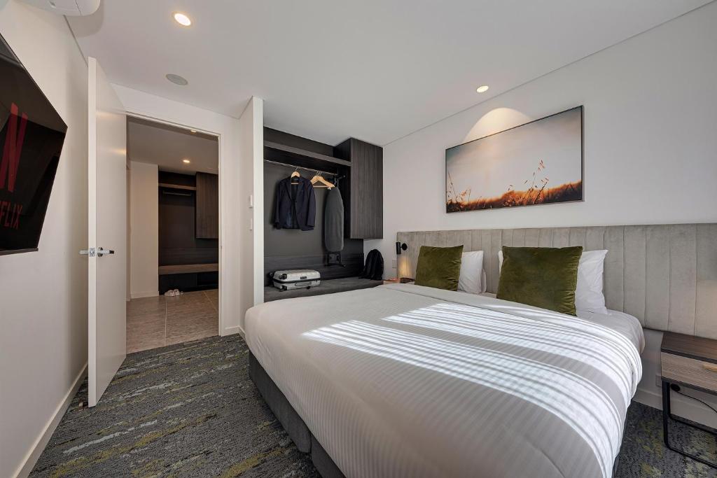 a bedroom with a large white bed in a room at Littomore Suites Kingswood in Penrith