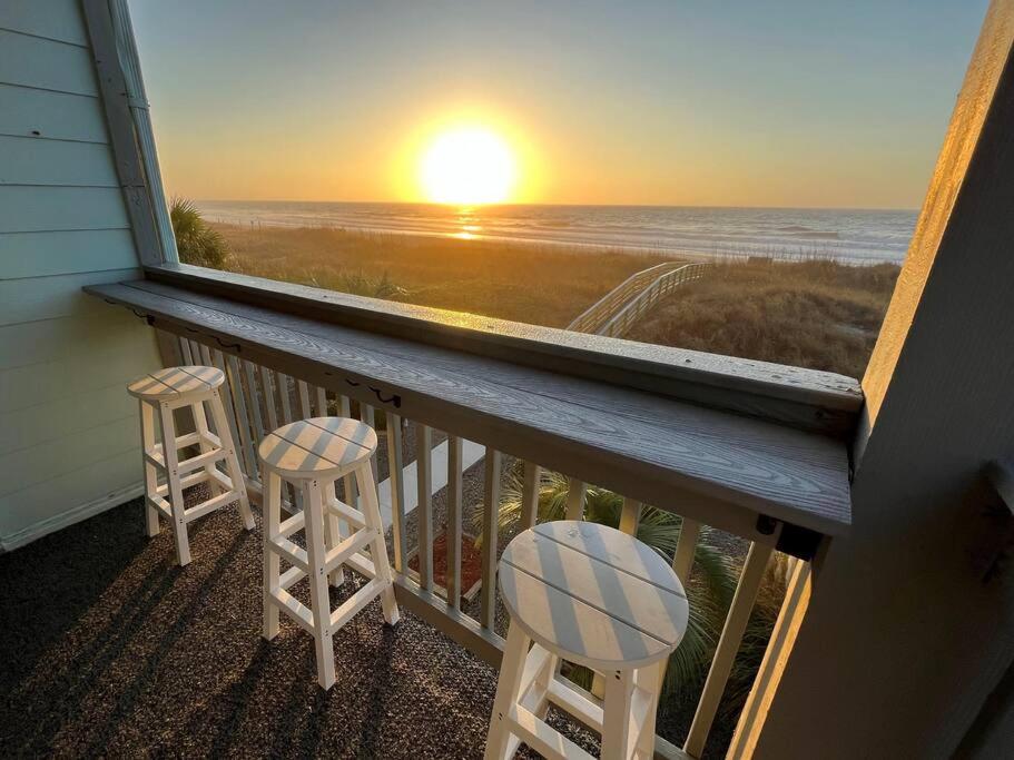 a balcony with two stools and a view of the ocean at Direct Ocean Front 3BR/2BA Dog Friendly **OCEANFRONT** in Myrtle Beach