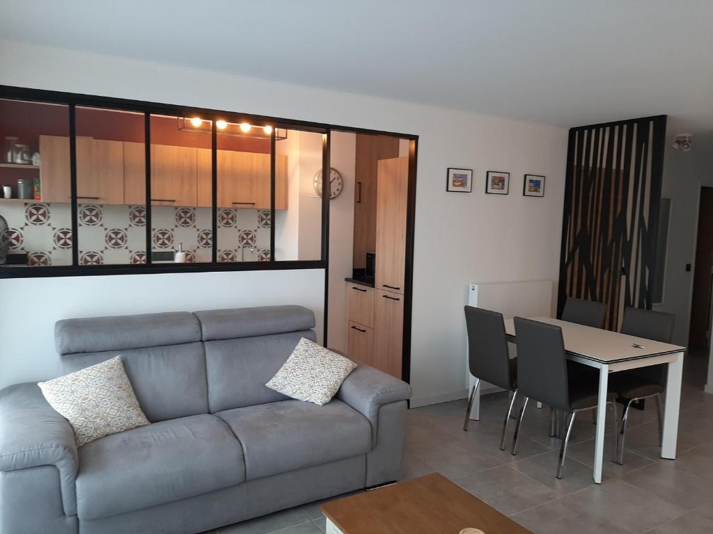 un salon avec un canapé et une table dans l'établissement Appartement T3 rénové à 10 min du centre-ville avec balcon, garage et WIFI à Saint-Jean-de-Luz - FR-1-239-584, à Saint-Jean-de-Luz