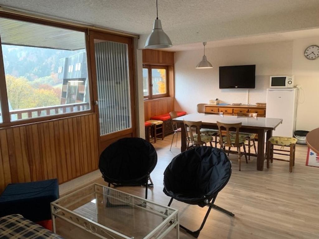 un salon avec une table et une salle à manger dans l'établissement F2 bis tout confort avec balcon au pied des pistes, parking et local à skis, Mont-Dore - FR-1-415-100, à Le Mont-Dore