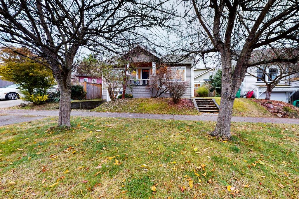 two trees in the grass in front of a house at Woodlawn Escape in Seattle