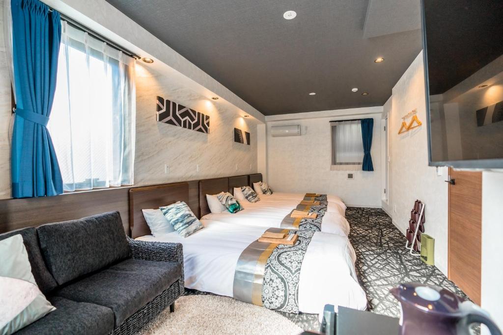 una camera da letto con un letto grande e un divano di UCHI Asakusabashi a Tokyo