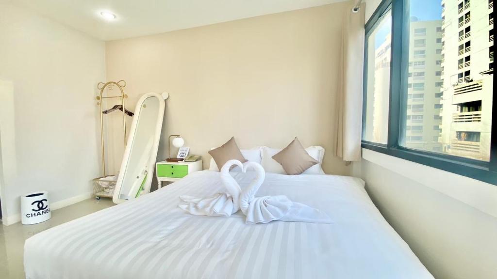 una camera da letto con un letto bianco e decorazioni a cuore di ABCYQ Hotel a Bangkok