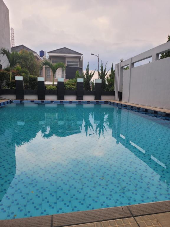 una piscina con acqua blu in un edificio di Gemintang House At Arcadia Residence a Cireungit