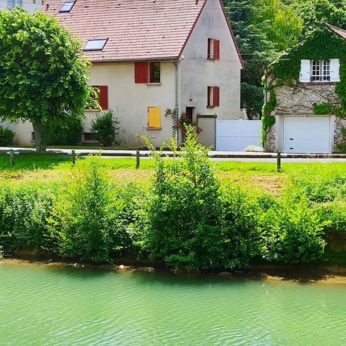 une maison à côté d'une rivière avec une maison dans l'établissement Le Jardin d'Eden, à Château-Thierry