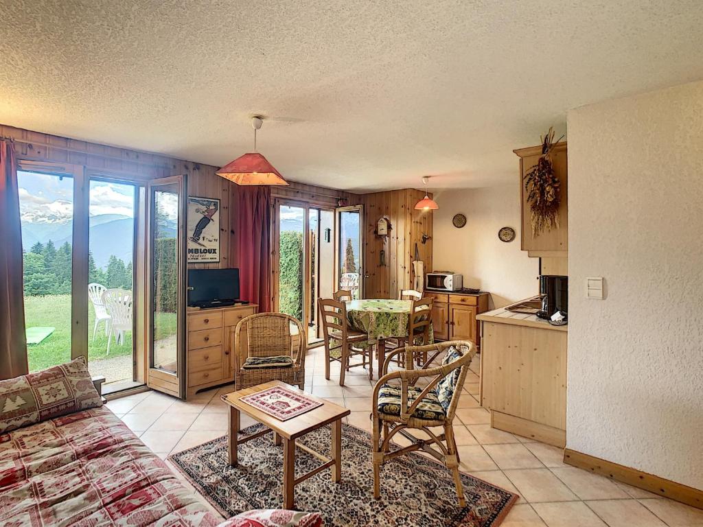 ein Wohnzimmer mit einem Tisch und Stühlen sowie eine Küche in der Unterkunft Appartement Combloux, 3 pièces, 5 personnes - FR-1-560-33 in Combloux
