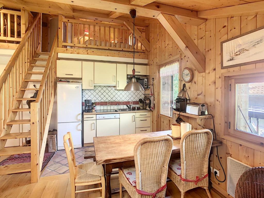 une cuisine avec une table et des chaises dans une cabine dans l'établissement Appartement cosy avec mezzanine, au pied des pistes à Combloux, parking inclus - FR-1-560-25, à Combloux