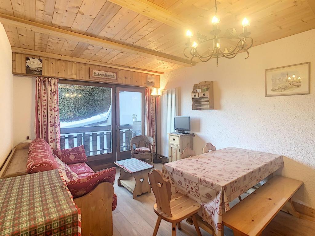 un salon avec une table et un canapé dans l'établissement Studio cosy avec cabine, pied des pistes à Combloux, balcon, casier à skis, équipements modernes - FR-1-560-56, à Combloux