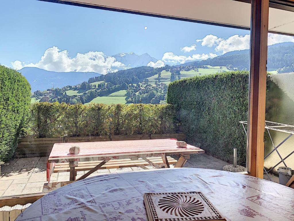 a table and a bench on a patio with a view at Charmant studio près du centre de Combloux avec kitchenette - FR-1-560-54 in Combloux