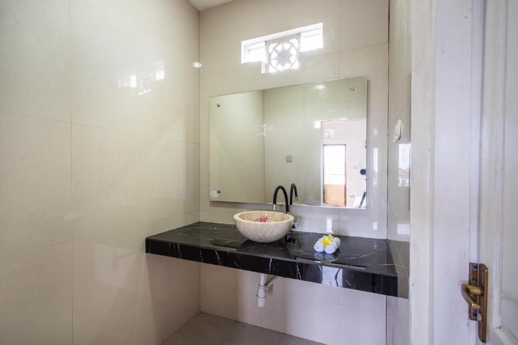 a bathroom with a sink and a large mirror at Lavanda guesthouse/homestay in Jimbaran