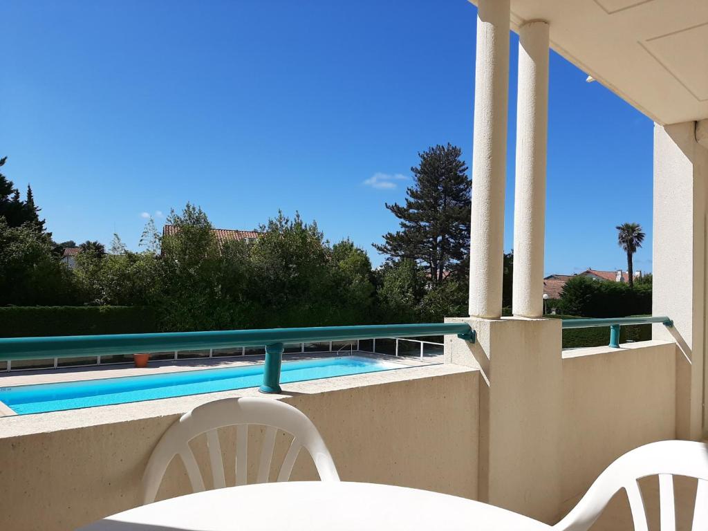 a balcony with two chairs and a swimming pool at Appartement Ciboure, 2 pièces, 4 personnes - FR-1-239-551 in Ciboure