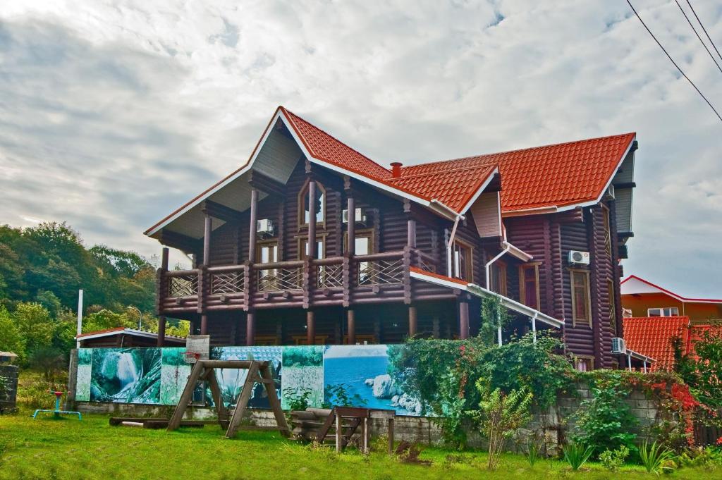 una gran casa de madera con techo rojo en Hobza Hutor, en Loo