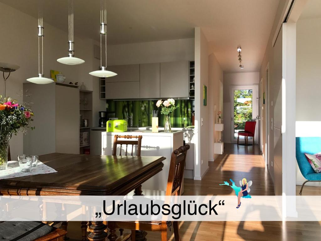 cocina y comedor con mesa y sillas en Ferienwohnung Urlaubsglück- lichtdurchflutete Wohnung mit Balkon und Seesicht en Lindau