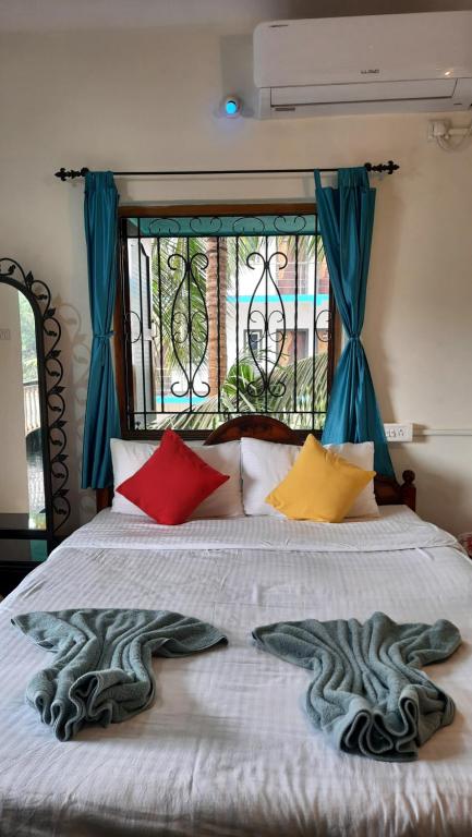 Ένα ή περισσότερα κρεβάτια σε δωμάτιο στο Tropical Wave Hostel Morjim