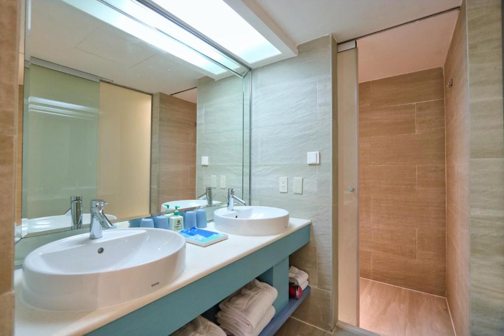 a bathroom with two sinks and a large mirror at Kenting Long Beach Hotel in Checheng