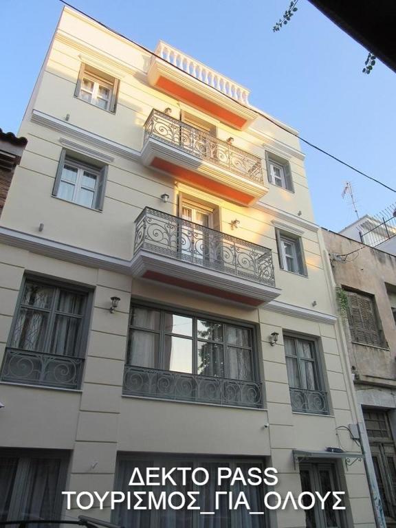 a tall white building with a balcony on it at UrbanStay in Athens