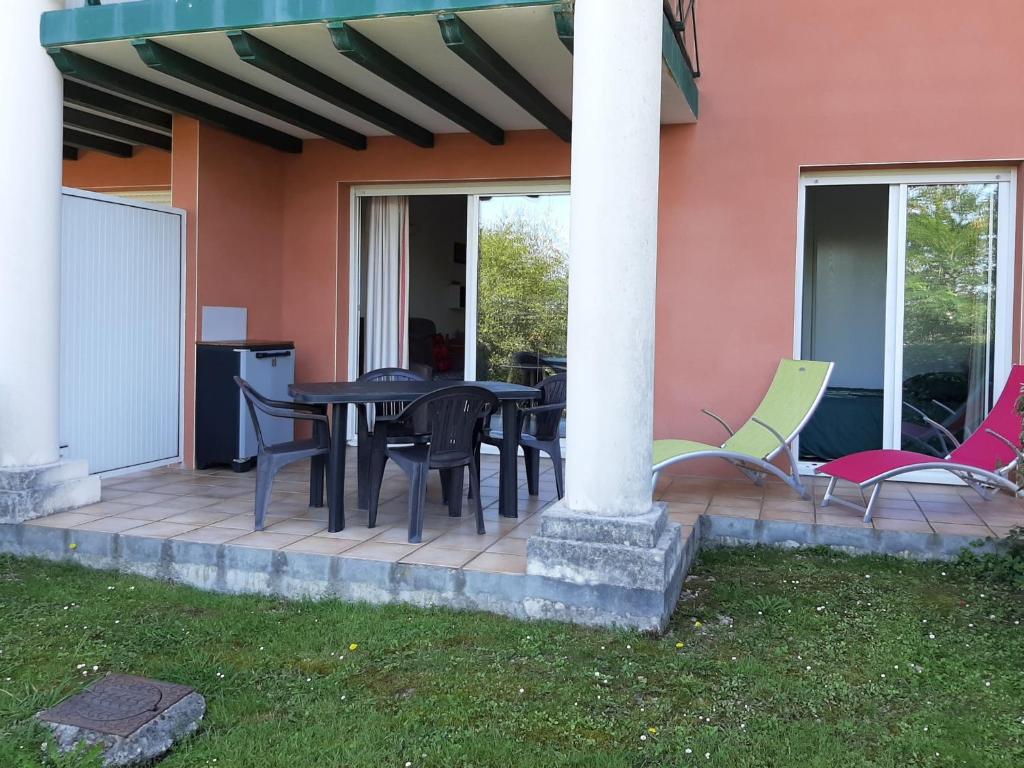 a patio with black tables and chairs next to a house at Appartement Ciboure, 2 pièces, 4 personnes - FR-1-239-511 in Ciboure