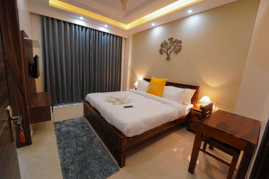 Lime Tree Two BHK Service Apartment Golf Course Road Gurgaon في جورجاون: غرفة نوم بسرير وطاولة ونافذة