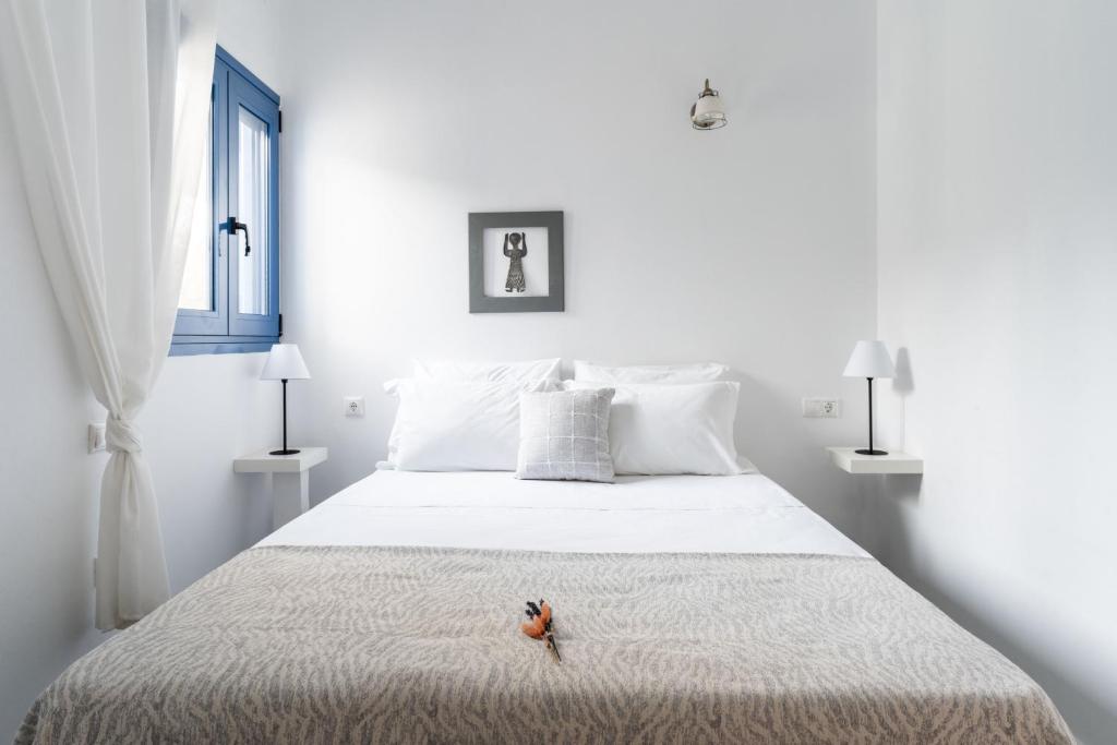 a white bedroom with a large bed with white pillows at Alasthas in Gavrio