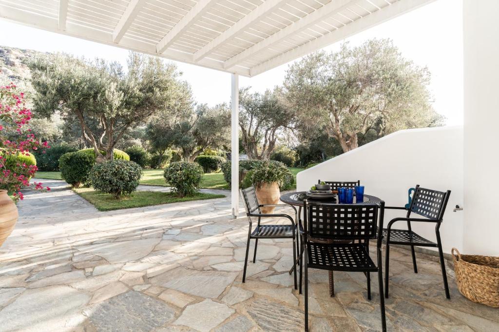 a patio with a table and chairs and trees at Alasthas in Gavrio