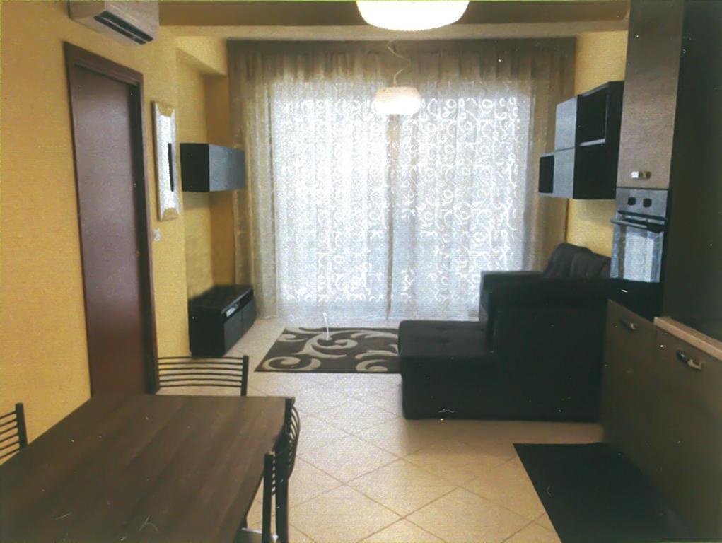 a living room with a couch and a table and a window at Casa Airone in SantʼAlessio Siculo