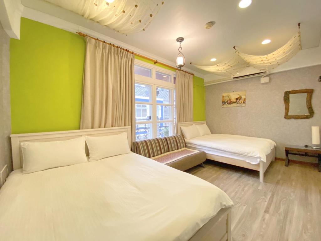 a bedroom with two beds and a green wall at Dot Minsu in Wujie