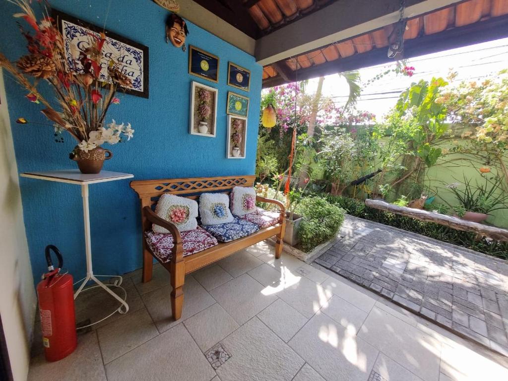 Pousada Casa da Lucinha في فورتاليزا: شرفة مع مقعد في الجدار الأزرق