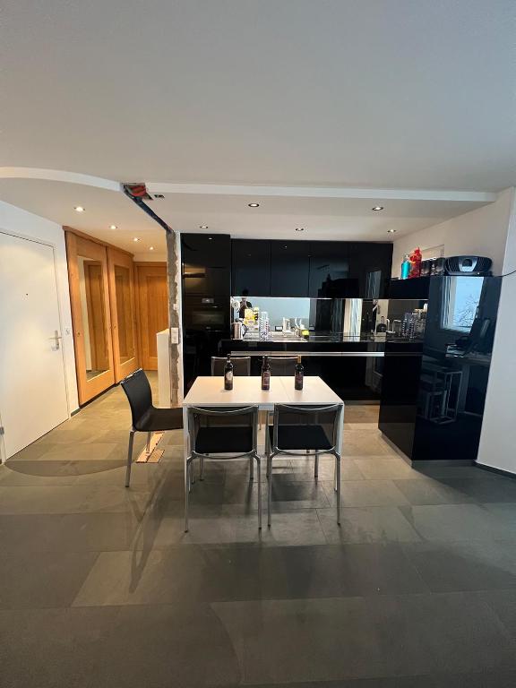 cocina con mesa blanca y sillas en una habitación en SmartHome Top of the World, en St. Moritz