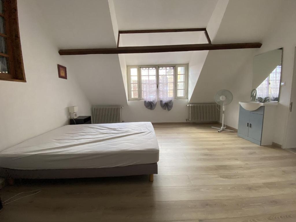 a white bedroom with a bed and a wooden floor at Appartement La Roche-Posay, 2 pièces, 5 personnes - FR-1-541-40 in La Roche-Posay