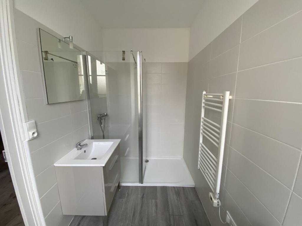 a white bathroom with a sink and a shower at Appartement La Roche-Posay, 2 pièces, 5 personnes - FR-1-541-40 in La Roche-Posay