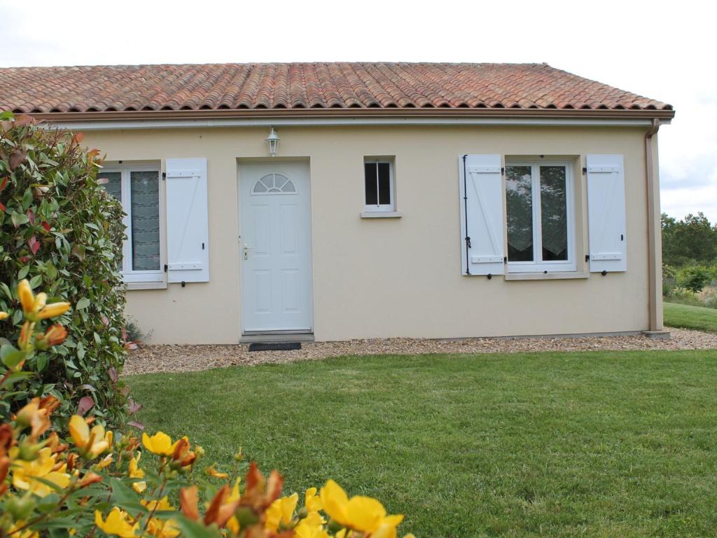 uma casa branca com uma porta azul e janelas em Maison La Roche-Posay, 3 pièces, 5 personnes - FR-1-541-47 em La Roche-Posay