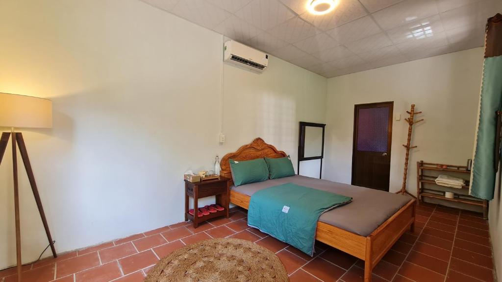 um quarto com uma cama e um candeeiro em Maison du Pays de Bến Tre em Ben Tre