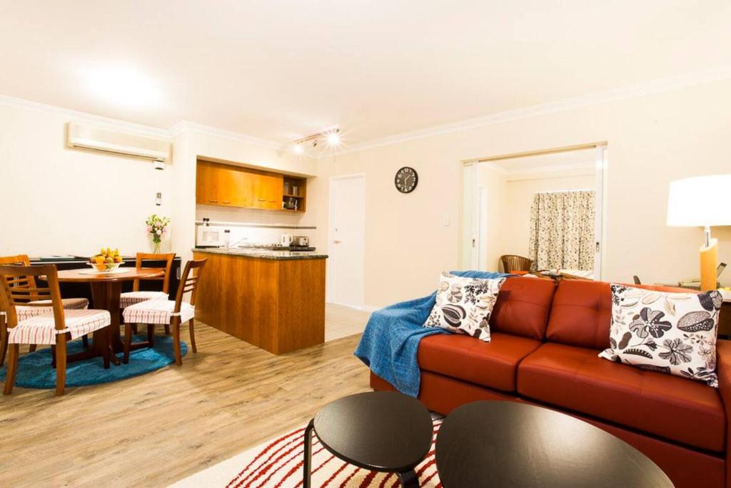 uma sala de estar com um sofá e uma sala de jantar em Perth City Living 105 em Perth