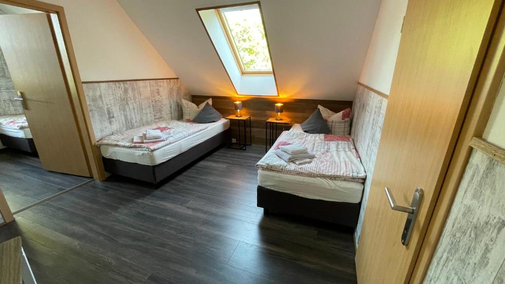 バート・ファリングボステルにあるHof Düshopのベッド2台と窓が備わる小さな客室です。