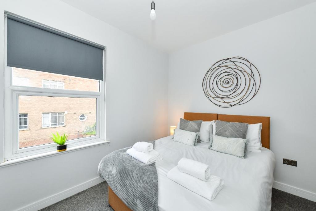 a white bedroom with a bed and a window at Long Eaton Modern 4bed House in Long Eaton