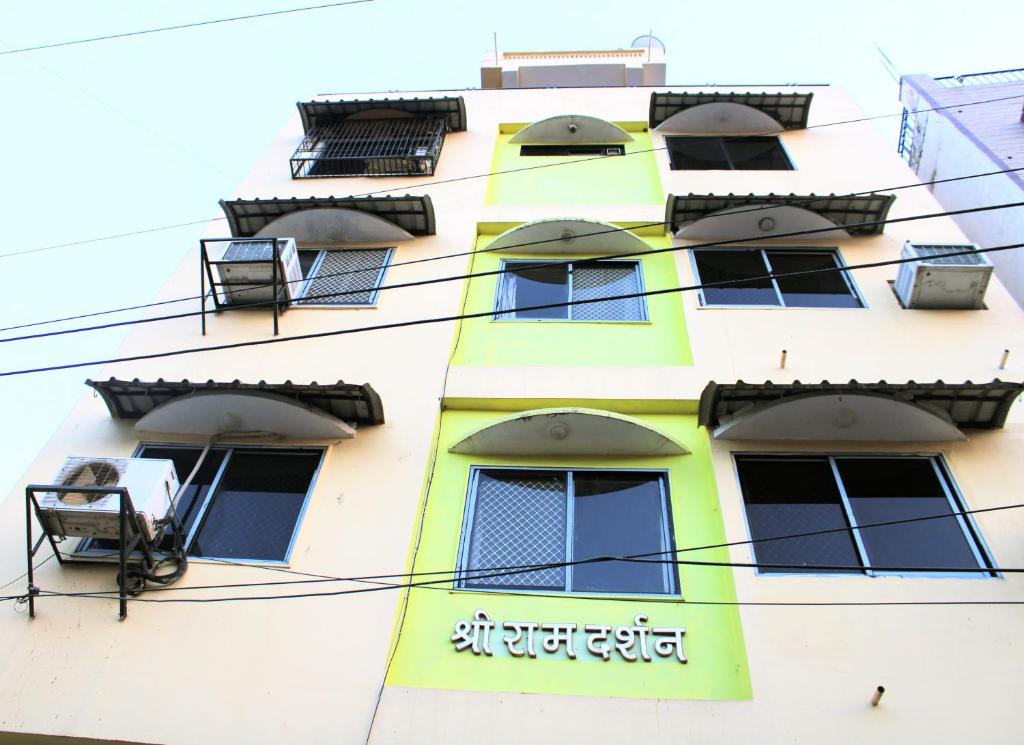 un edificio amarillo con ventanas laterales en Maruti Group of Hotels - Shree Ram Darshan, en Nathdwara