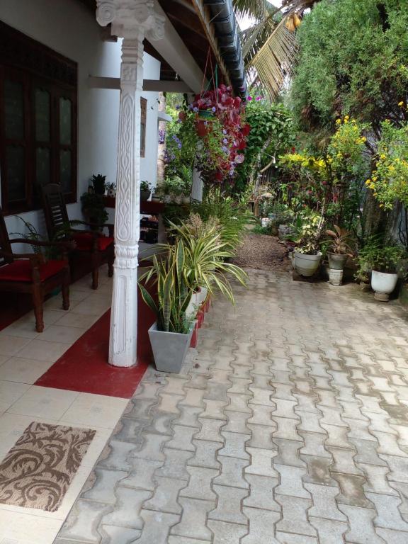 a patio with potted plants and a column at Gem Villa in Weligama