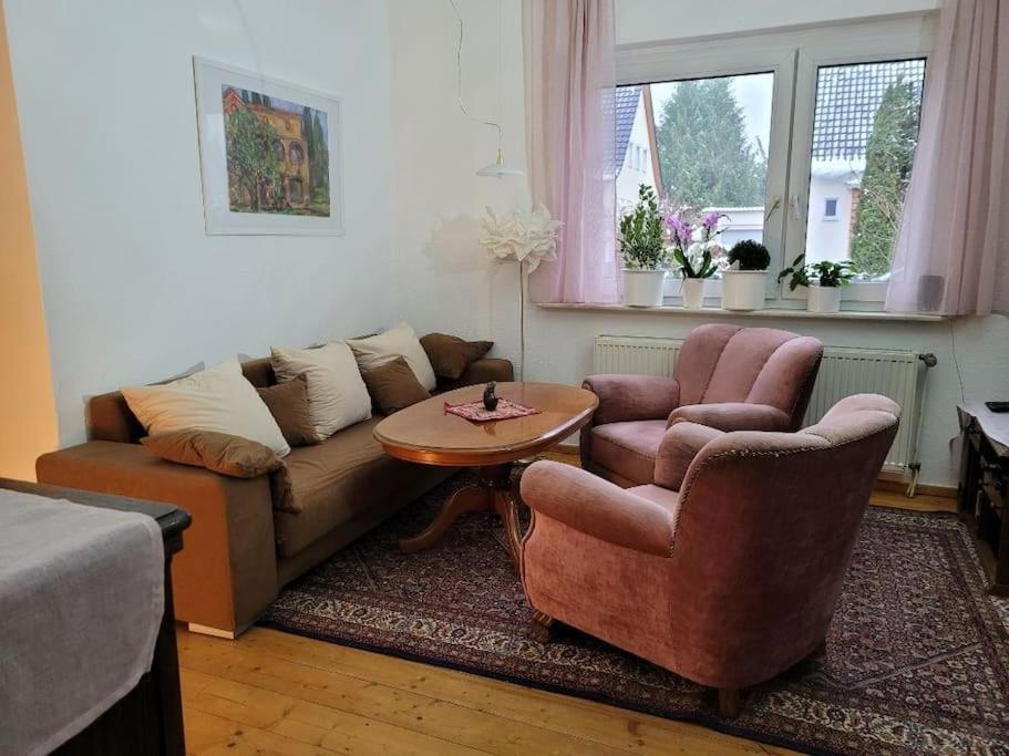 een woonkamer met een bank, 2 stoelen en een tafel bij Gästewohnung " Am Harsdorf " in Maagdenburg