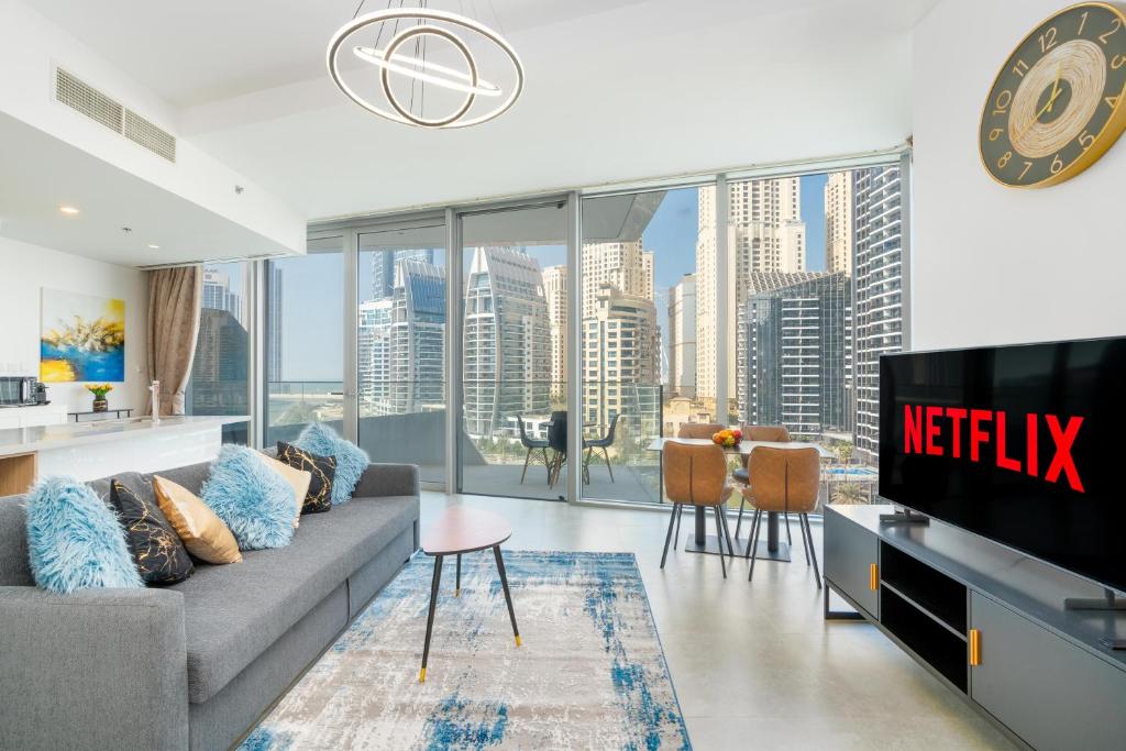 sala de estar con sofá y TV en Vacay Lettings - Waterfront Luxury home with full Marina view, en Dubái