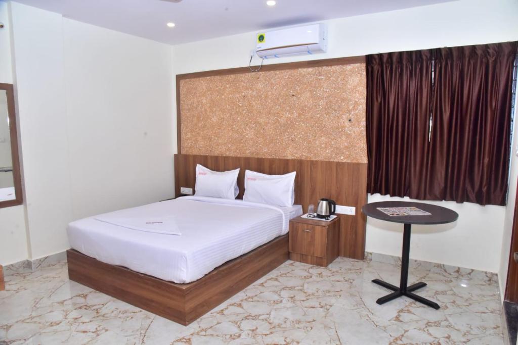 um quarto com uma cama e uma mesa com um telefone em hotel fortune sky em Bangalore